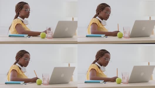 在笔记本电脑Spbi上搜索信息后，时髦女学生用钢笔写笔记。女高清在线视频素材下载