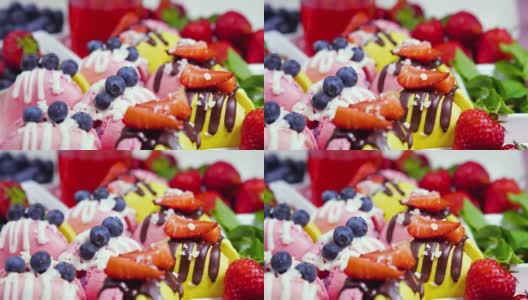 马卡龙，手工制作的精美甜品，用新鲜草莓和蓝莓装饰的巧克力甜点，精致的黄色和粉色蛋糕，糖和健康食品高清在线视频素材下载