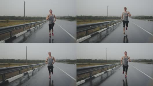 运动员在雷雨中沿着高速公路快速奔跑，正面视图。运动员冒雨在公路上跑马拉松。短跑运动员在锻炼高清在线视频素材下载