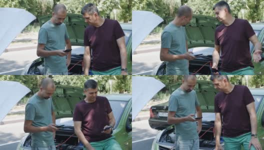 汽车电池充电。男人站在汽车旁边，帮助朋友给汽车电池充电高清在线视频素材下载
