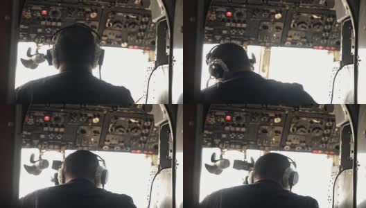 男性飞行员在飞行过程中工作和坐在飞机驾驶舱的后视图。Avki高清在线视频素材下载