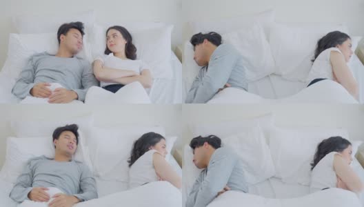 亚洲年轻夫妇躺在床上痛苦地争吵后。新婚男女为他们的争吵冲突而心碎，睡在卧室里。家庭problem-separation概念。高清在线视频素材下载