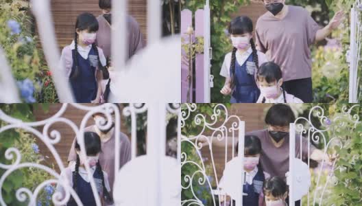 回到学校的亚洲华人母亲送她的两个女儿上学从家在前院的房子防护口罩高清在线视频素材下载