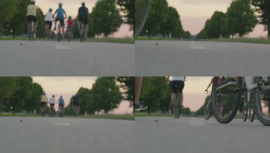 一个带着三个孩子在绿树成荫的乡间小路上骑单车的家庭高清在线视频素材下载