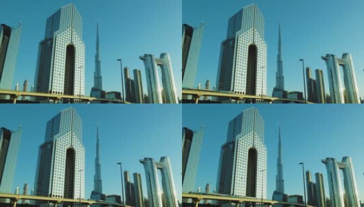 美丽的迪拜城市摩天大楼或天际线与哈利法塔。迪拜RTA地铁经过。从迪拜谢赫扎耶德路看到的景象高清在线视频素材下载