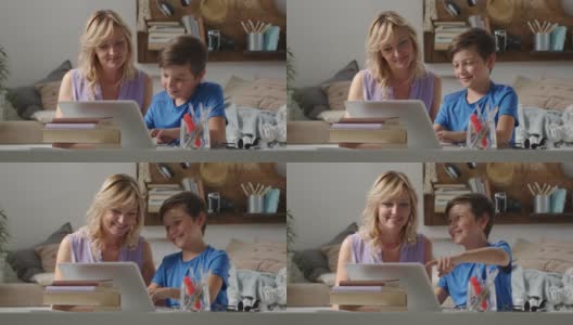 快乐的家庭在家里，妈妈和儿子玩电脑，父母和孩子在笔记本电脑上浏览互联网，小男孩的东西指向显示器高清在线视频素材下载