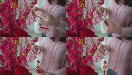 亚洲华人微笑的妇女在樱花上装饰中国新年的装饰品高清在线视频素材下载