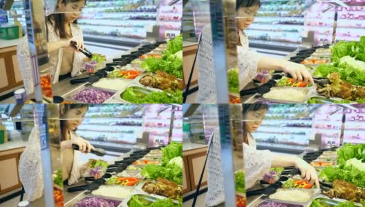 Young woman selecting fresh salad高清在线视频素材下载