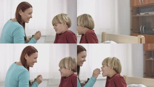 母亲给儿子喂止咳糖浆高清在线视频素材下载