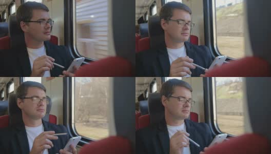 一个拿着手机的男人从火车窗口欣赏风景高清在线视频素材下载