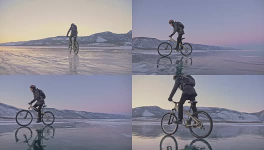 男人在冰上骑自行车。骑自行车的人穿着灰色羽绒服，背着背包，戴着头盔。结冰的贝加尔湖的冰。自行车的轮胎上覆盖着特殊的尖钉。高清在线视频素材下载