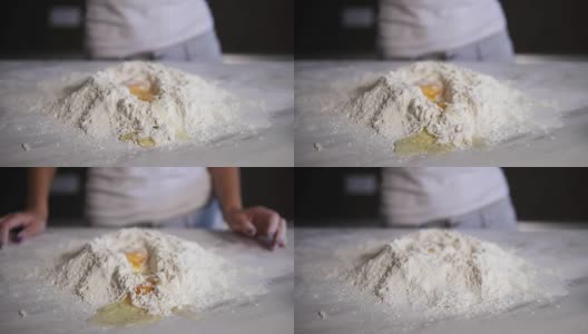 特写镜头:鸡蛋掉进厨房桌上的面粉里。Slowmotion拍摄高清在线视频素材下载