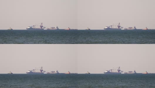 一艘货轮在朦胧的海面上，在地平线上行驶。在甲板上载运散货的多用途船。航运服务高清在线视频素材下载