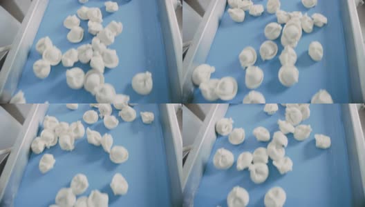 在饺子工厂的自动机器生产过程的近距离镜头。新鲜生Pelmeni移动输送带。在食品工厂操作的工业机械。高清在线视频素材下载