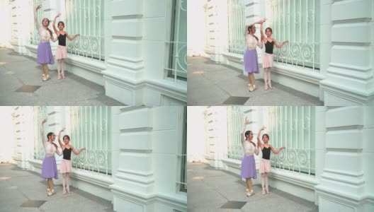 在泰国曼谷一个阳光明媚的日子里，一名年轻的芭蕾舞教师正在教学生，一名正在练习芭蕾舞的白人青少年芭蕾舞者在当地街道上的一间教室里举起手臂。概念活泼的年轻妇女和孩子在周末的活动。高清在线视频素材下载