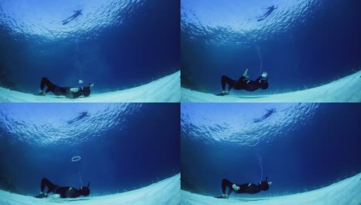 自由潜水者有乐趣和吹泡泡水下高清在线视频素材下载