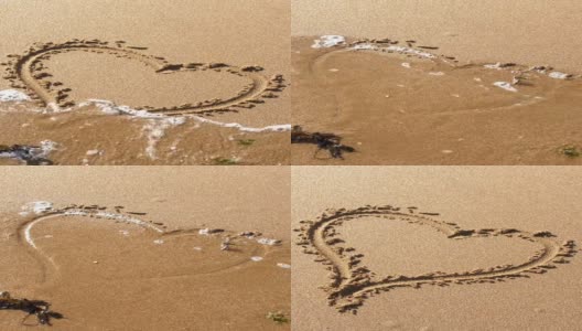 被海水卷走的沙上画的心形。破碎的心。高清在线视频素材下载