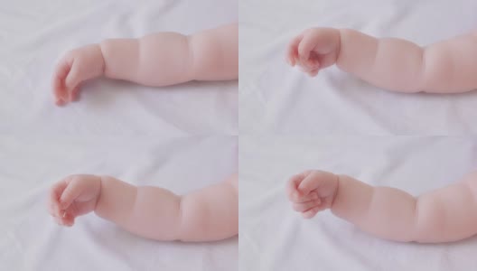 靠近可爱的小裸手可爱的蹒跚学步的婴儿躺在柔软的白色床上俯视图高清在线视频素材下载