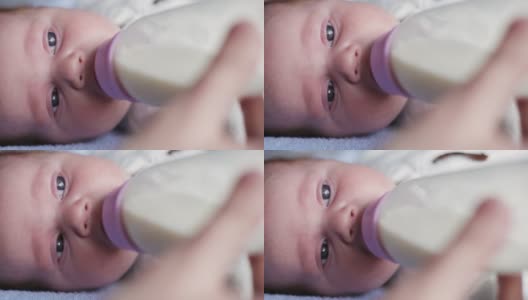 一个可爱的新生儿通过奶瓶被喂牛奶的特写高清在线视频素材下载