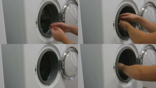 男人用手把洗好的衣服放进洗衣机。洗衣房有一台白色的大洗衣机。高清在线视频素材下载