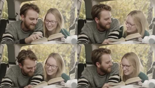 年轻的男人和女人一起在车后座看书高清在线视频素材下载