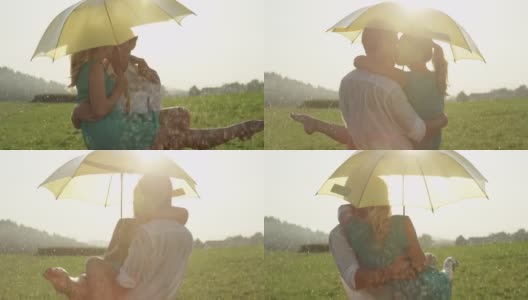 慢镜头:在凉爽的夏雨中，年轻的情侣拥抱亲吻。高清在线视频素材下载