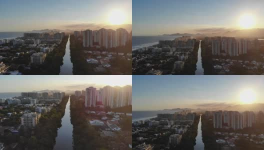在夕阳的映衬下，空中拍摄的巴拉达蒂茹卡的马拉潘迪运河。一边是高耸的住宅楼，另一边是海滩。巴西的里约热内卢高清在线视频素材下载