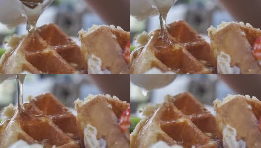 特写女子在华夫饼上倒蜂蜜糖浆高清在线视频素材下载