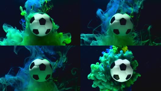 足球在一个惊人的背景。绿色和蓝色的墨水在水中在黑色的背景高清在线视频素材下载