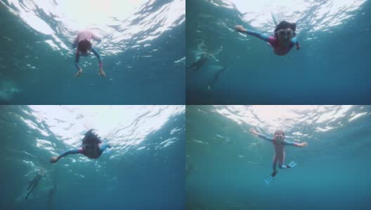 一个勇敢的小女孩独自在蓝色的深海里游泳和潜水。高清在线视频素材下载