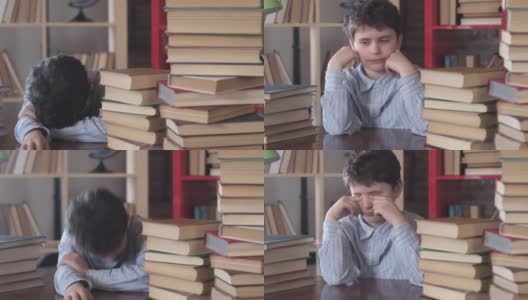 一个男生睡在桌子上。在学校的一堆书中叫醒一个孩子。高清在线视频素材下载