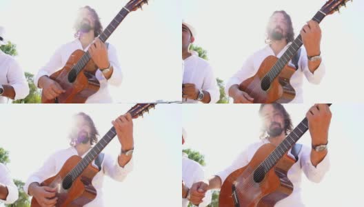 一个留着长发和胡子的吉他手在街上演奏高清在线视频素材下载