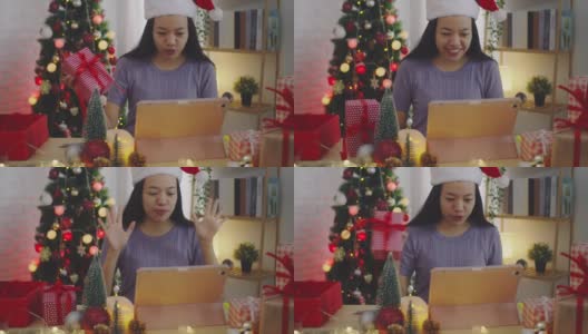 亚洲妇女使用平板电脑会议和视频电话在线在家里与圣诞树装饰节日的背景。圣诞节庆祝活动的概念。4 k慢动作。高清在线视频素材下载