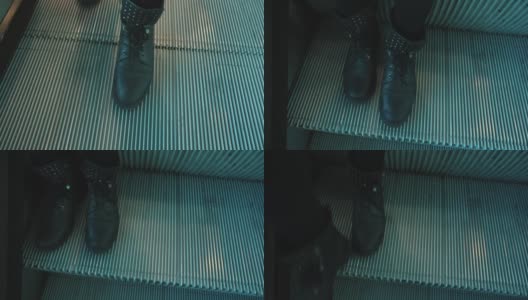 穿着黑色靴子的脚站在扶梯台阶上。自动运动行人。高清在线视频素材下载