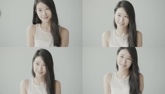 一位身穿白大褂的温柔美丽的亚洲女子在摄影棚拍摄视频。风吹过她长长的黑发，微笑着展望未来高清在线视频素材下载