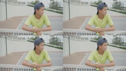 混合亚洲十多岁男孩网球运动员，健康的青少年运动员训练，积极的健康概念高清在线视频素材下载