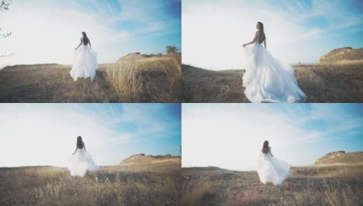 奔跑的新娘穿着令人惊叹的长裙穿过风景。高清在线视频素材下载