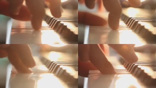 一个男人的手在窗边弹奏电子钢琴。宜人的阳光从室内的窗户。高清在线视频素材下载