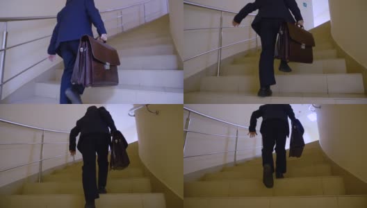 一个拿着公文包的男生正从学校走廊的楼梯上跑去上课。年轻的商人快步走上楼在大厅的商务办公室。高清在线视频素材下载