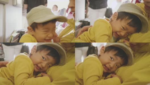 飞机上快乐的小男孩。亚洲小男孩和他的母亲旅行。高清在线视频素材下载