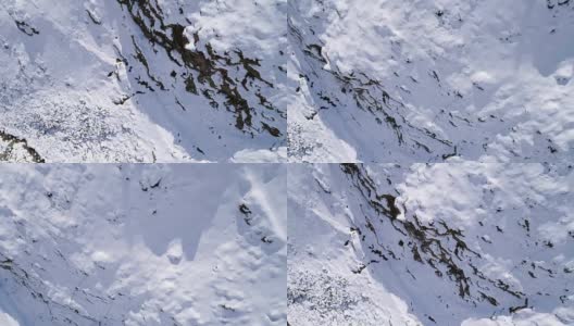 高空飞过雪山，山脊，山谷建立者向前飞行。户外雪高山野生自然景观在冬季顶视图与阳光和阴影。4k无人机飞行建立镜头高清在线视频素材下载