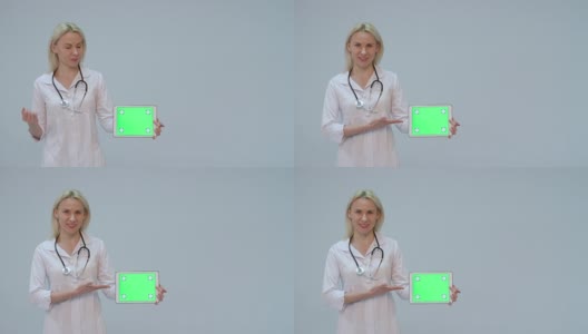 一个女医生的肖像与白色大衣和平板与绿色屏幕和听诊器微笑高清在线视频素材下载