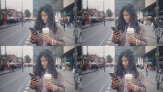 在柏林亚历山大广场(AlexanderPlatz)的公交站，一个有着东方风情的女孩在等待有轨电车，她拍下了一部智能手机的屏幕高清在线视频素材下载