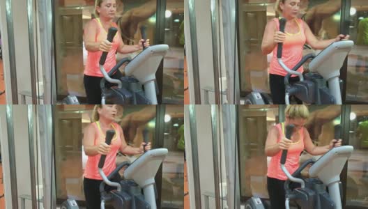 女人在健身房的步进机上训练。健康和健身的概念。高清在线视频素材下载