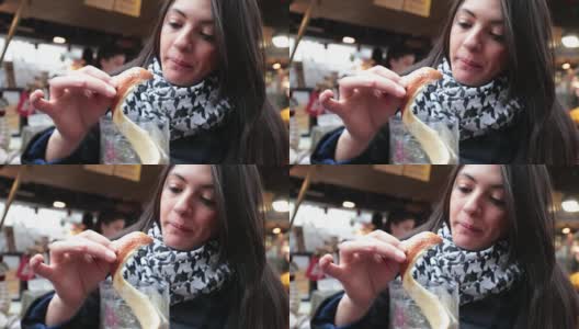 女孩吃着传统的匈牙利肉桂烟囱蛋糕甜点高清在线视频素材下载