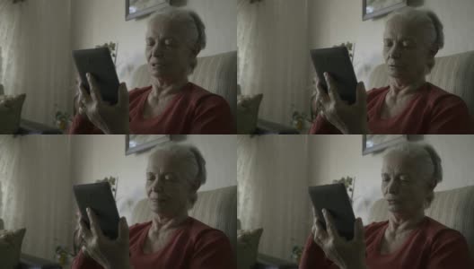 一个老太太正在用平板电脑视频通话高清在线视频素材下载