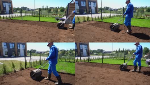 播后人工用压土机在院子内播撒草坪。万向节运动高清在线视频素材下载