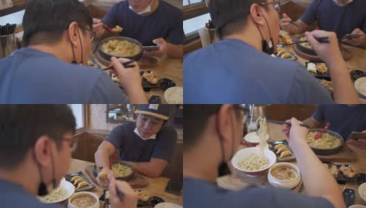 两名男子戴着面具在日本餐厅用餐，这是新常态高清在线视频素材下载