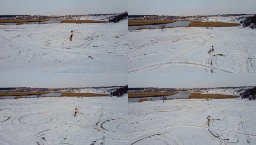 妈妈带着她的小女儿在山河边的积雪上滑行高清在线视频素材下载