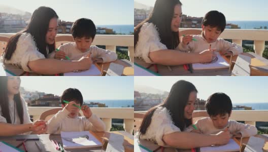 亚洲母亲和儿子一起在户外院子里做作业-学前儿童做绘画活动高清在线视频素材下载